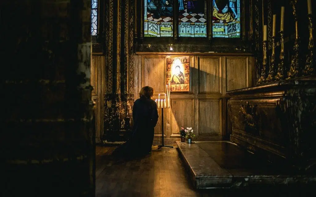 person praying in church at night